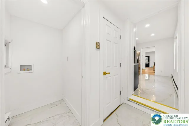 a view of a hallway with wooden floor and windows