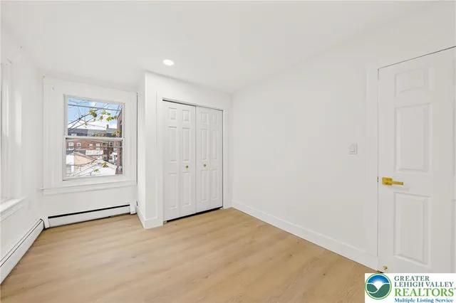 an empty room with windows and closet