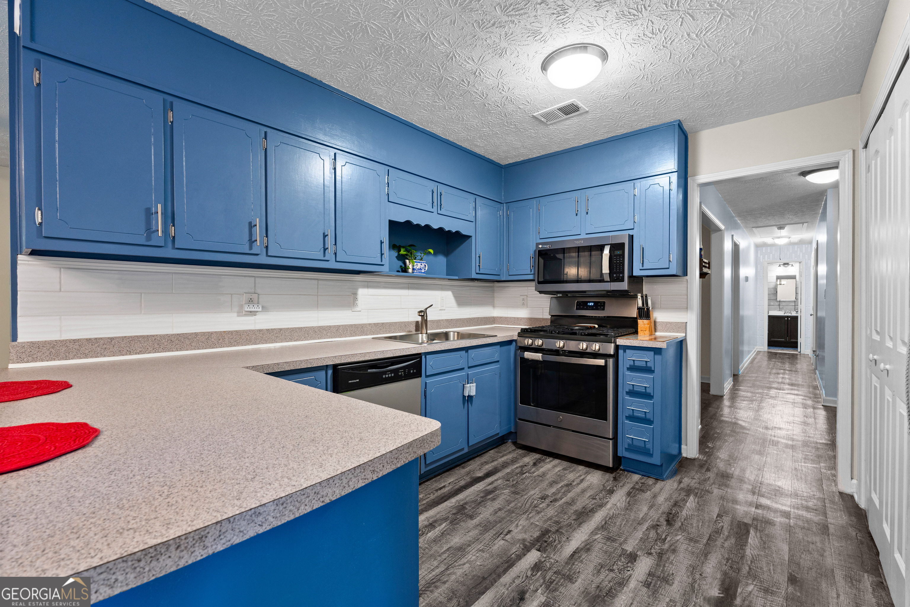 230 Ridge Road Tyrone, GA 30290 - Photo 15 of 47 a kitchen with stainless steel appliances granite countertop wooden cabinets a stove top oven a sink and dishwasher