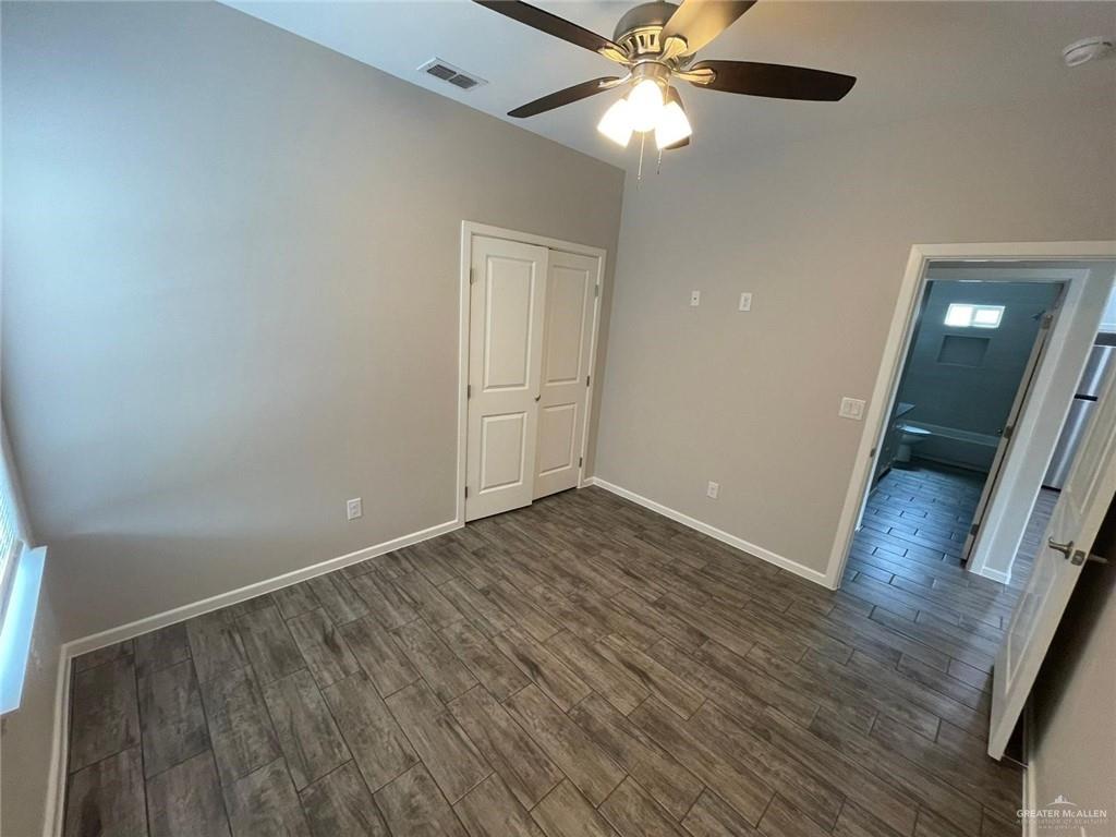 5901 Swallow Avenue, Unit 2 Mission, TX 78573 - Photo 7 of 11 an empty room with wooden floor fan and windows
