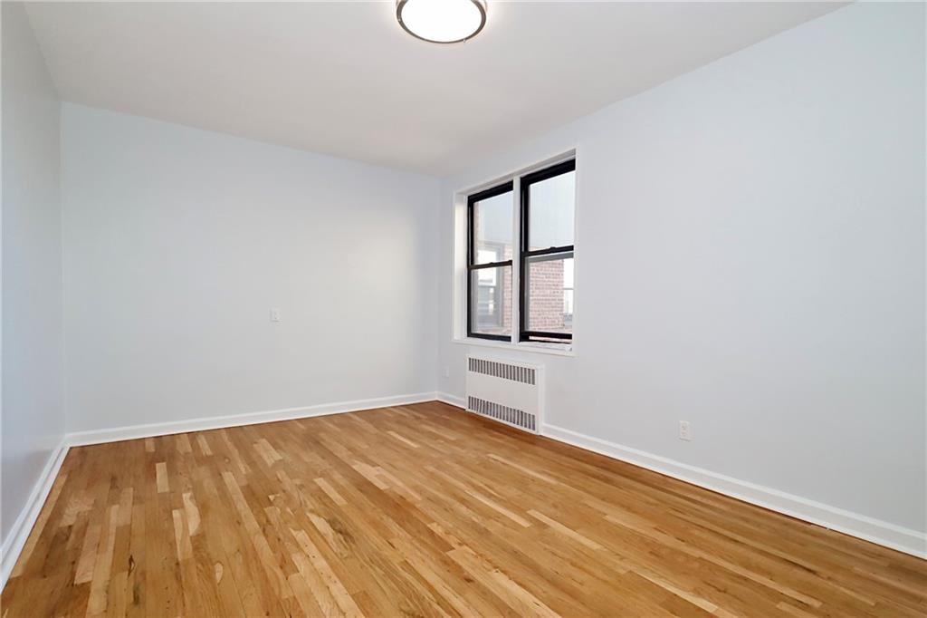 3025 Ocean Avenue, Unit 6E Brooklyn, NY 11235 - Photo 12 of 18 a view of empty room with wooden floor and fan