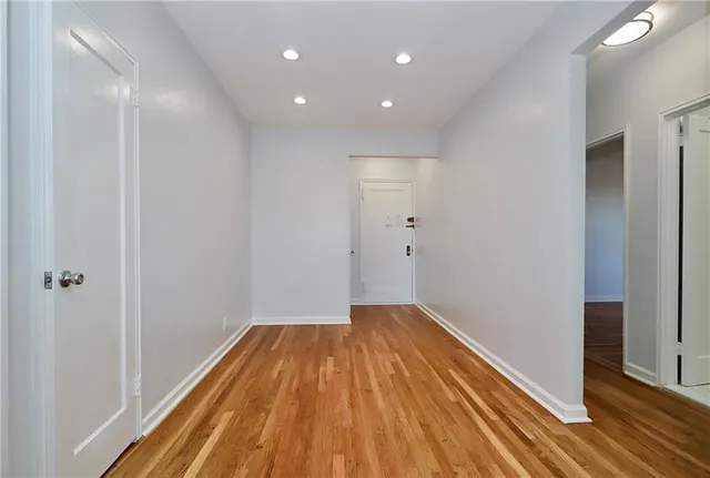 a view of a room with wooden floor and a hallway