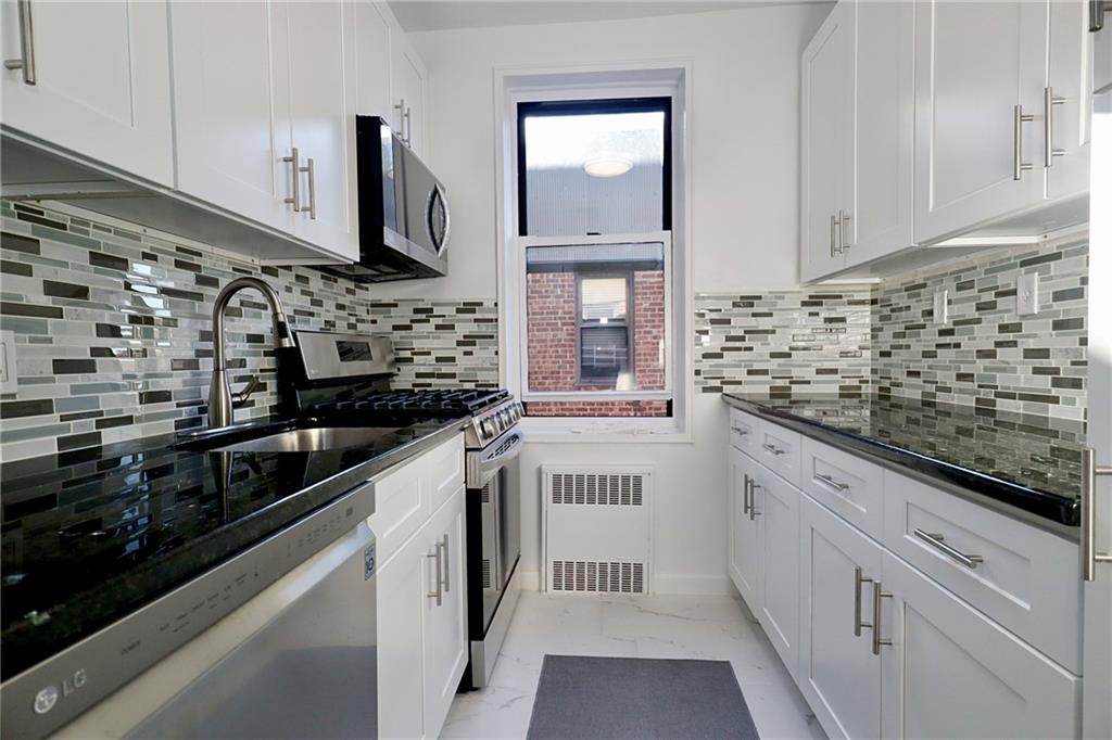 3025 Ocean Avenue, Unit 6E Brooklyn, NY 11235 - Photo 8 of 18 a kitchen with stainless steel appliances a sink stove and cabinets