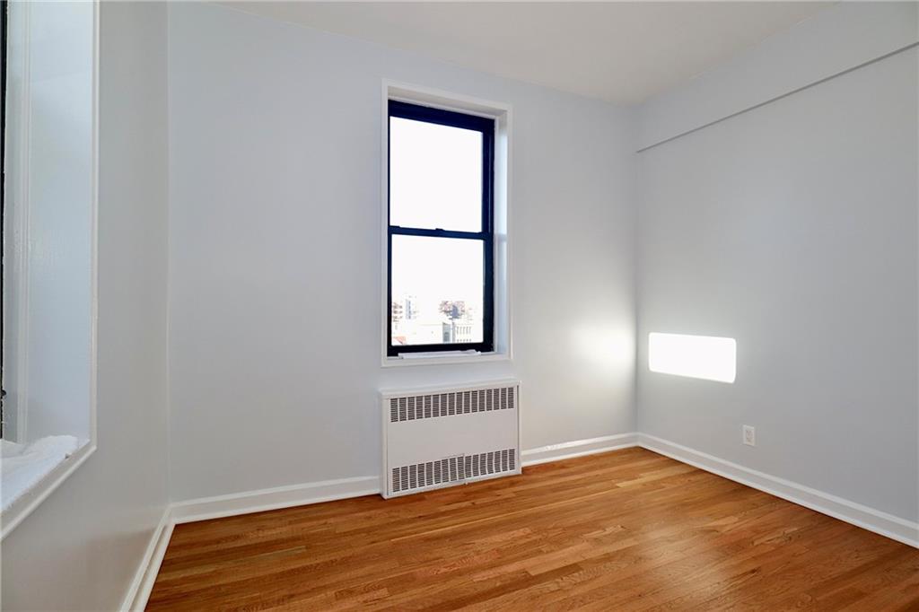 3025 Ocean Avenue, Unit 6E Brooklyn, NY 11235 - Photo 9 of 18 an empty room with wooden floor and windows