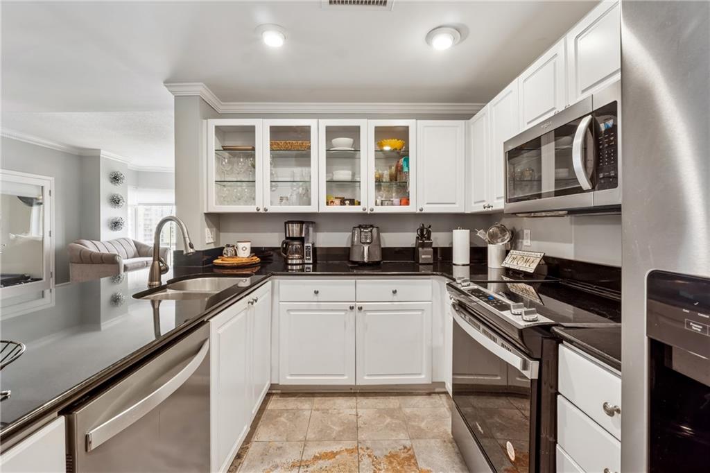 3475 Oak Valley Road Northeast, Unit 980 Atlanta, GA 30326 - Photo 7 of 42 a kitchen with stainless steel appliances granite countertop a stove and a sink