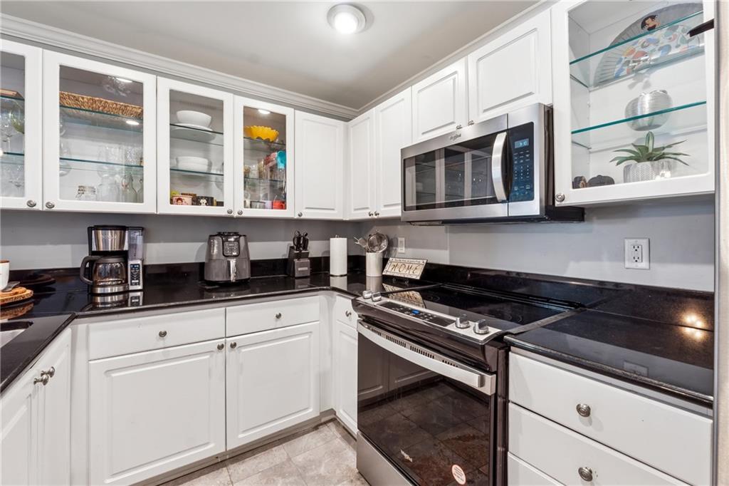 3475 Oak Valley Road Northeast, Unit 980 Atlanta, GA 30326 - Photo 8 of 42 a kitchen with granite countertop cabinets stainless steel appliances and a sink