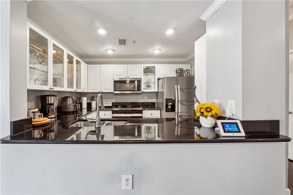 3475 Oak Valley Road Northeast, Unit 980 Atlanta, GA 30326 - Photo 10 of 42 a kitchen with stainless steel appliances granite countertop a refrigerator and a stove top oven