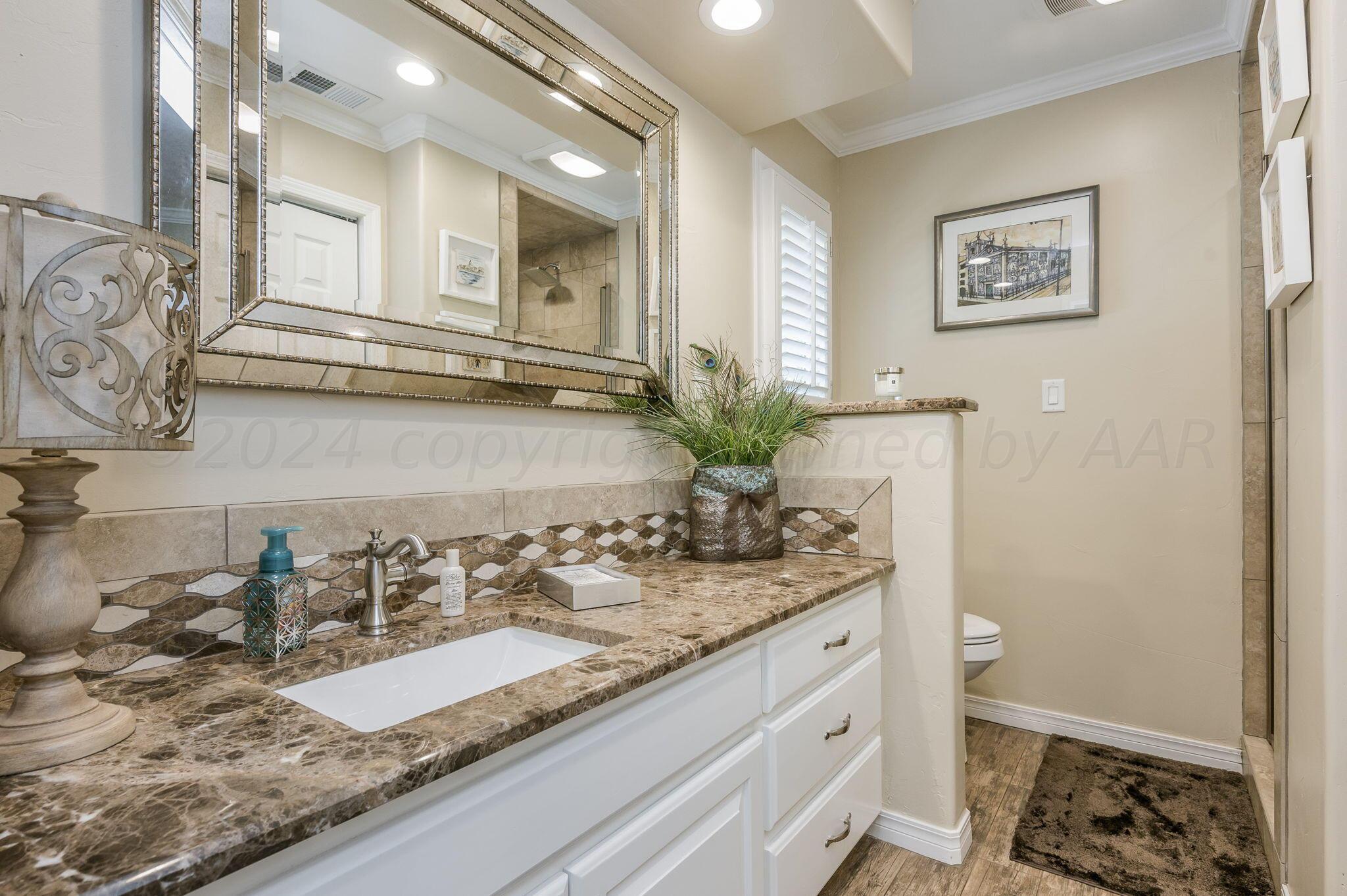 3518 Danbury Drive Amarillo, TX 79109 - Photo 24 of 59 a bathroom with a granite countertop sink and a mirror