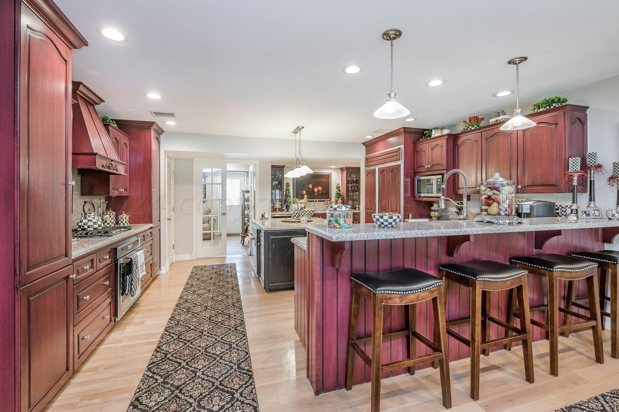 3518 Danbury Drive Amarillo, TX 79109 - Photo 8 of 59 a kitchen with stainless steel appliances kitchen island granite countertop a table chairs sink and wooden cabinets