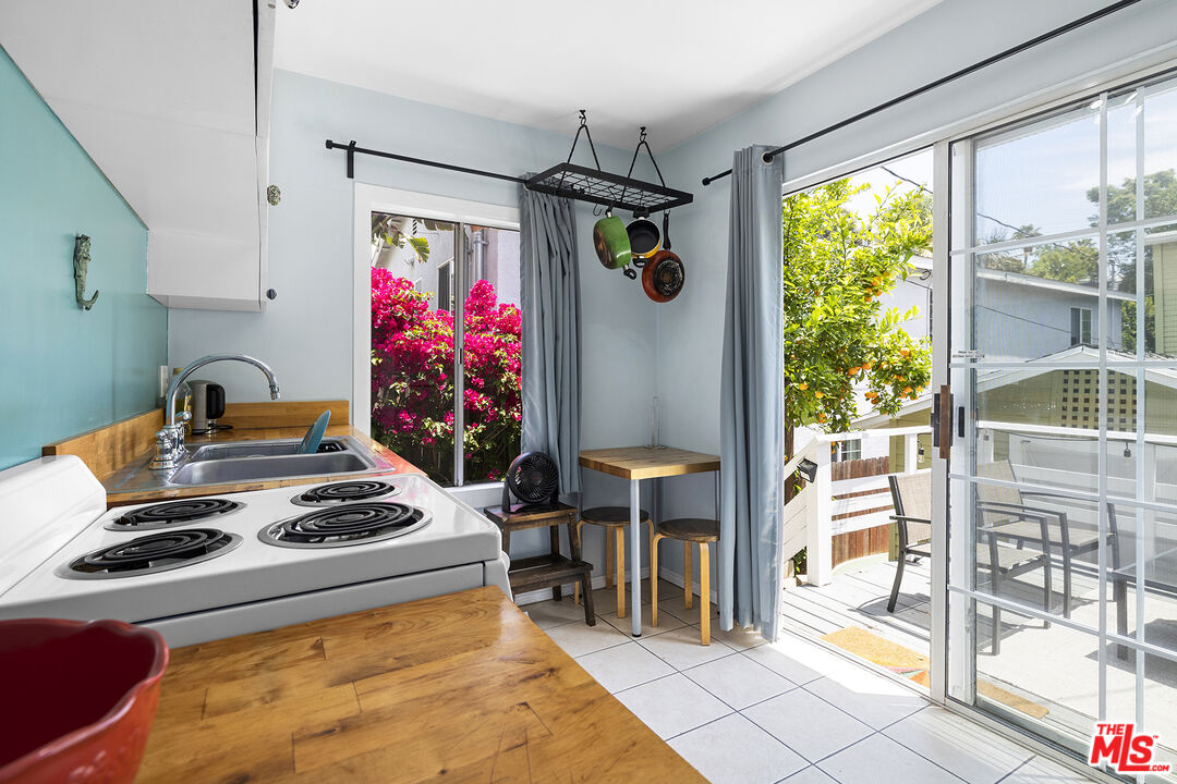 2105 Echo Park Avenue Los Angeles, CA 90026 - Photo 23 of 31 a kitchen with a stove a refrigerator and a dining table with wooden floor