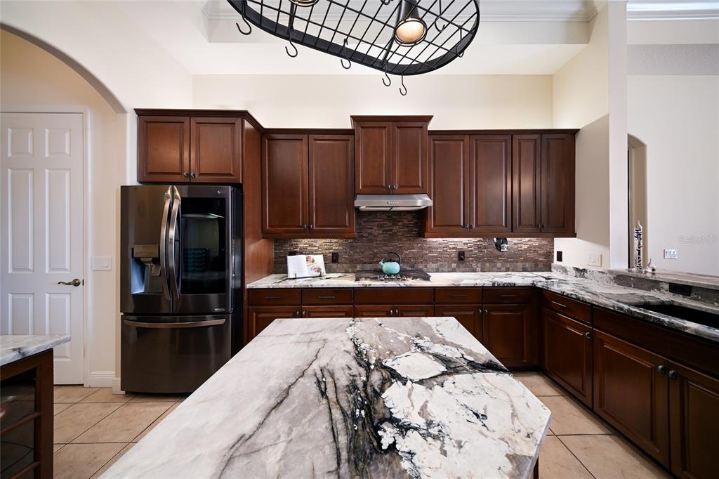 14806 Bowfin Terrace Lakewood Ranch, FL 34202 - Photo 5 of 58 a kitchen with stainless steel appliances granite countertop a refrigerator a stove a sink and a microwave