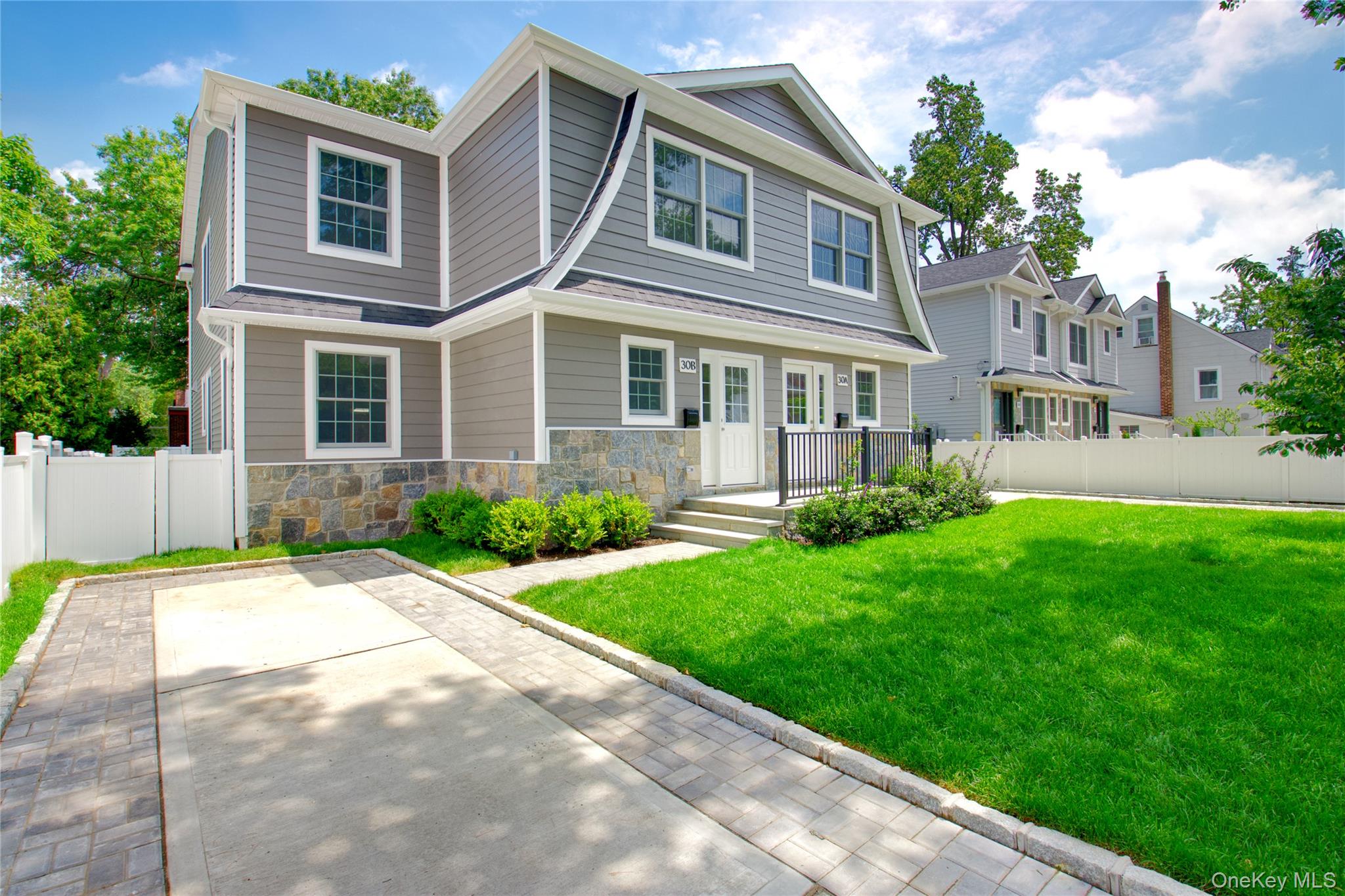 30 Kirkwood Road, Unit B Port Washington, NY 11050 - Photo 2 of 36 a front view of a house with a yard and trees