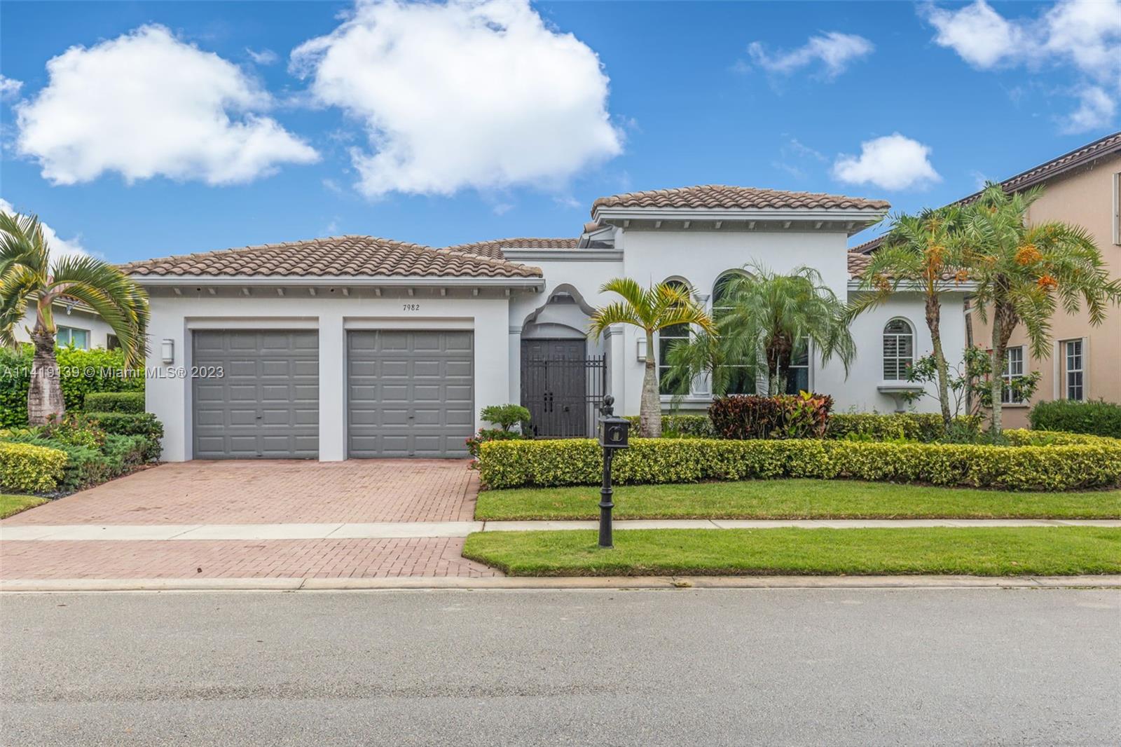 7982 Northwest 109th Lane Parkland, FL 33076 - Photo 1 of 71 a front view of a house with a garden and plants