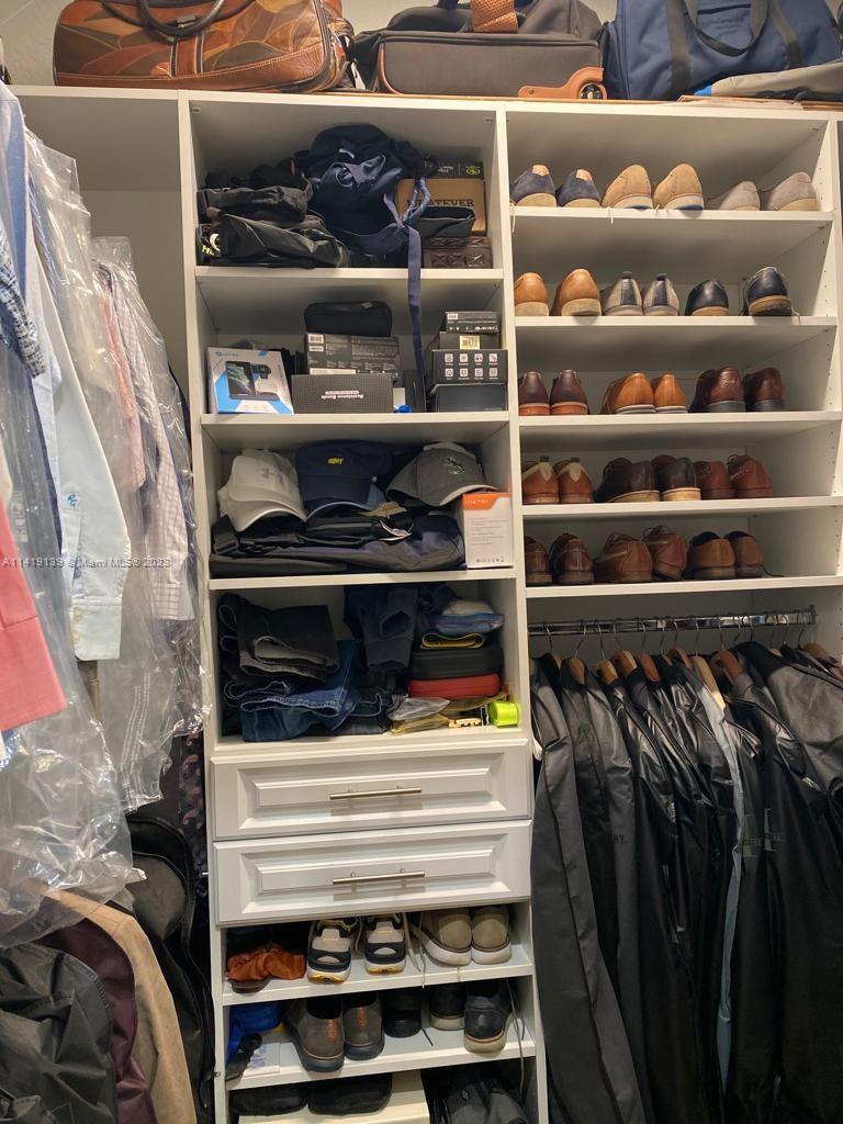 7982 Northwest 109th Lane Parkland, FL 33076 - Photo 14 of 71 a view of walk in closet with clothes and shoes