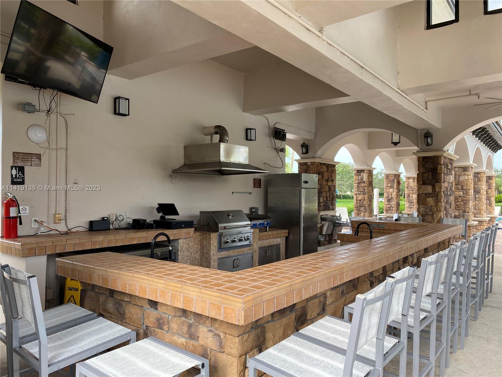 7982 Northwest 109th Lane Parkland, FL 33076 - Photo 65 of 71 a kitchen with furniture a flat screen tv and appliances