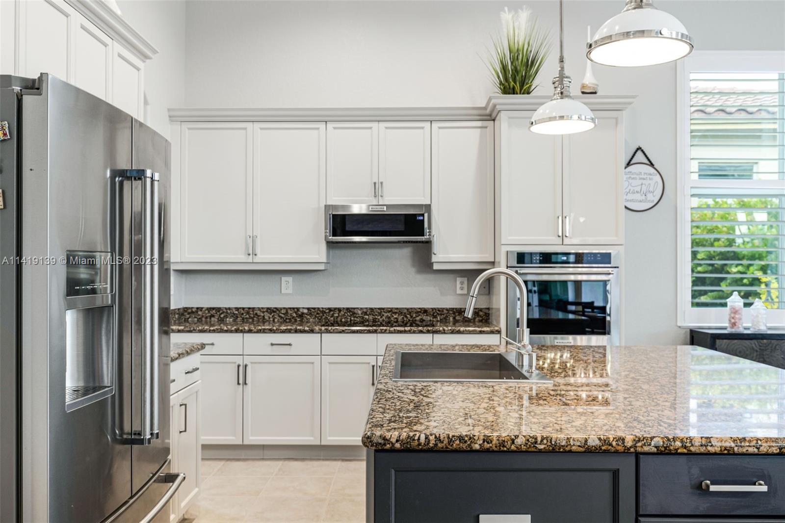 7982 Northwest 109th Lane Parkland, FL 33076 - Photo 7 of 71 a kitchen with stainless steel appliances granite countertop a stove a refrigerator and a granite counter tops with white cabinets