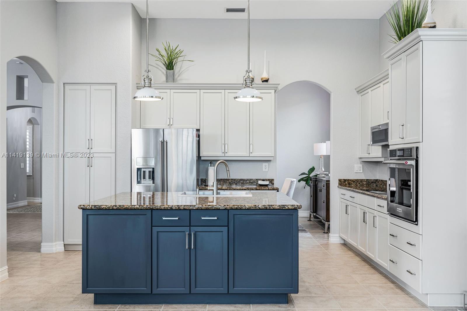 7982 Northwest 109th Lane Parkland, FL 33076 - Photo 8 of 71 a kitchen with kitchen island granite countertop a sink cabinets and stainless steel appliances