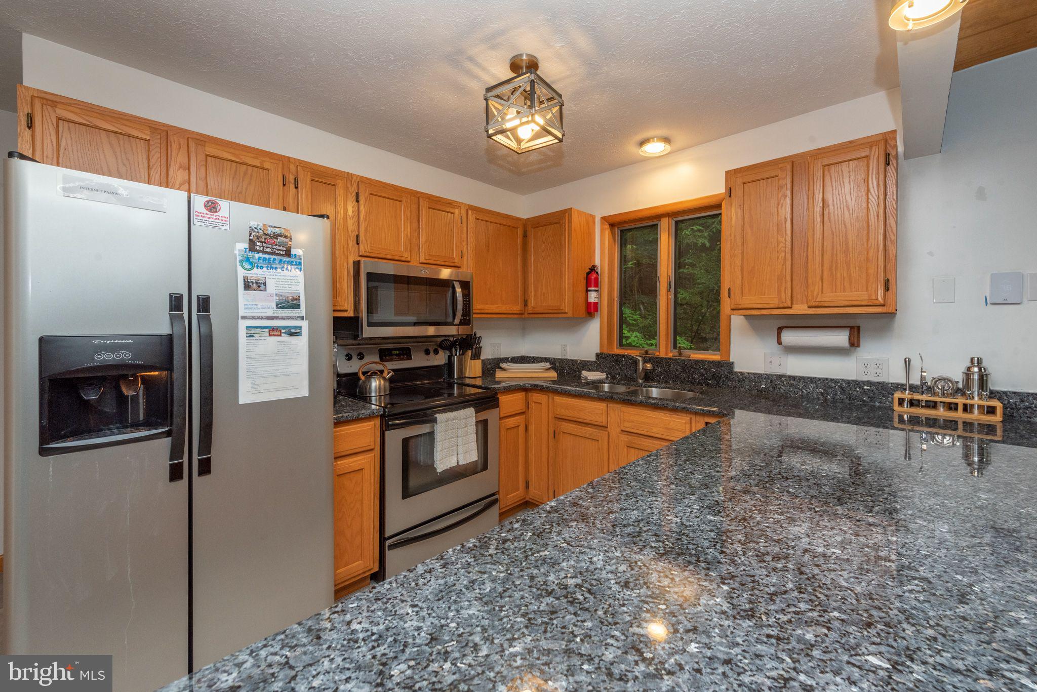 2667 Mayhew Inn Road Oakland, MD 21550 - Photo 8 of 44 a kitchen with stainless steel appliances granite countertop a refrigerator a stove top oven a sink and dishwasher