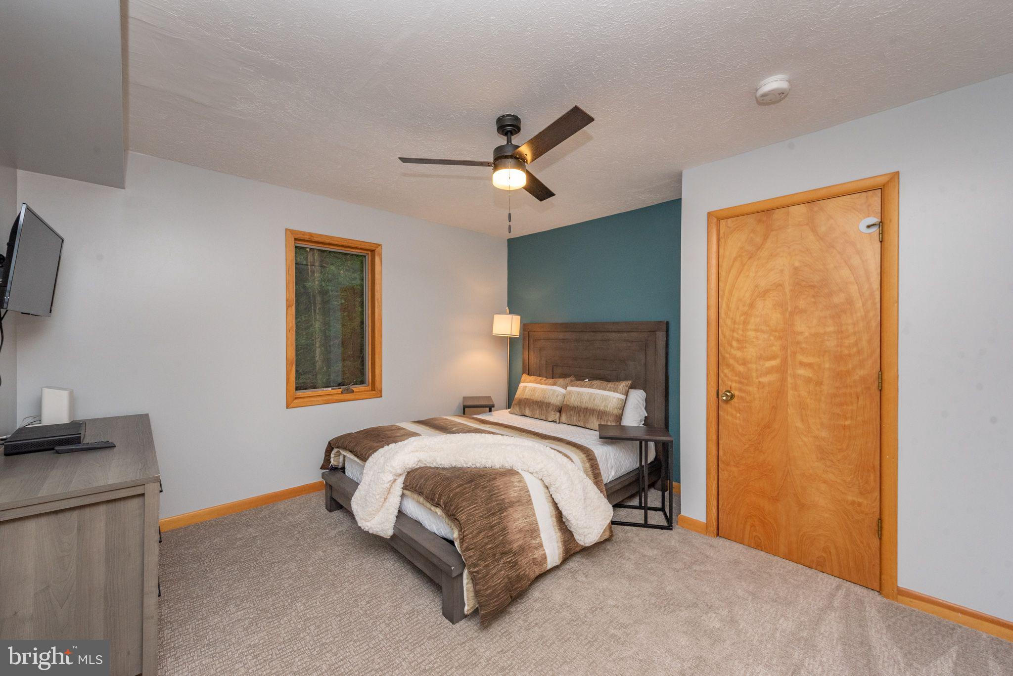 2667 Mayhew Inn Road Oakland, MD 21550 - Photo 9 of 44 a bedroom with a bed ceiling fan and a window