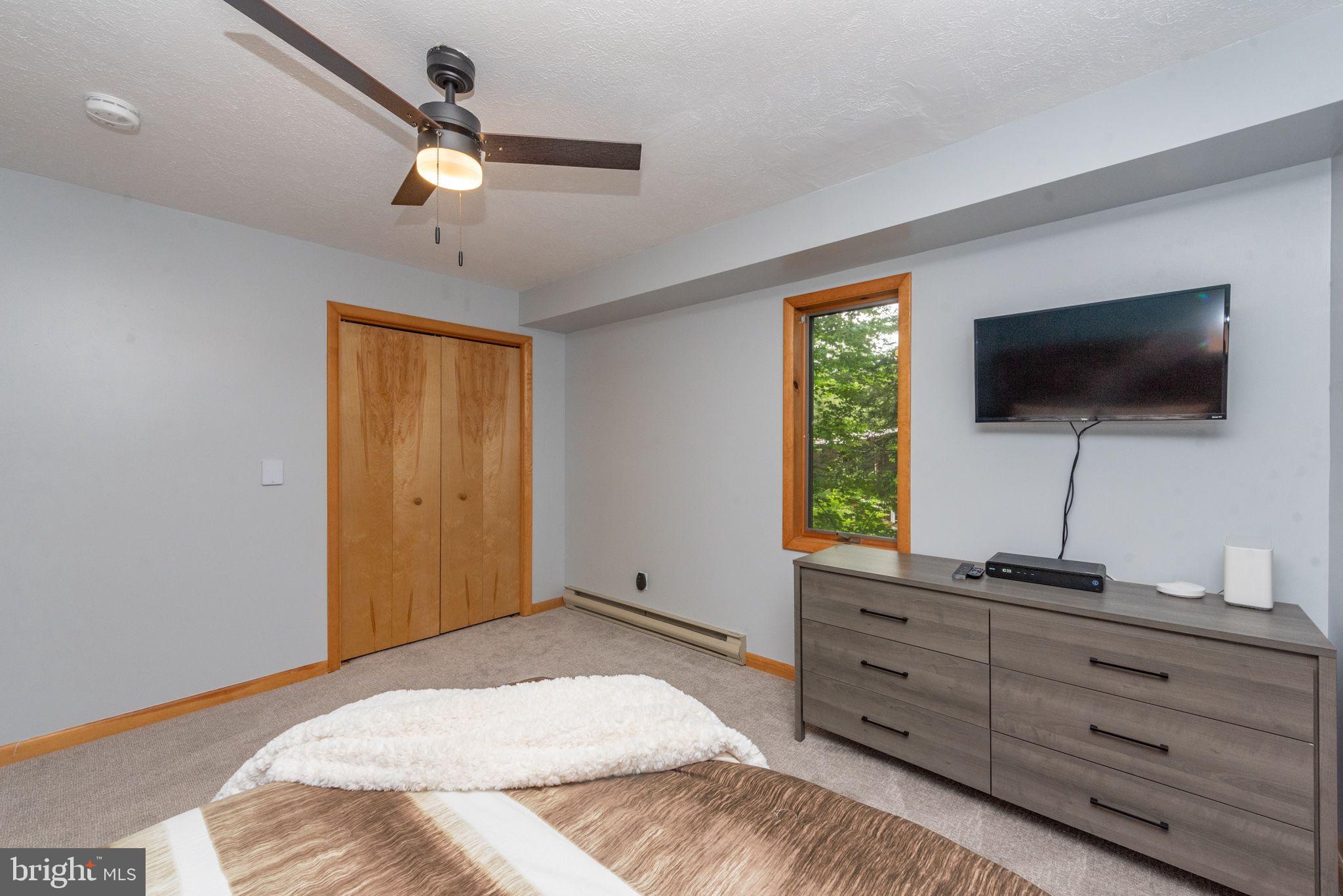 2667 Mayhew Inn Road Oakland, MD 21550 - Photo 10 of 44 a bedroom with a bed and a flat screen tv