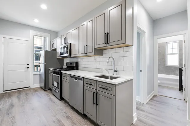 a kitchen with stainless steel appliances granite countertop a sink stove and refrigerator