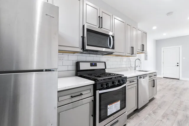 a kitchen with stainless steel appliances white cabinets and a stove top oven