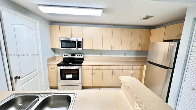 a kitchen with a refrigerator sink and stove