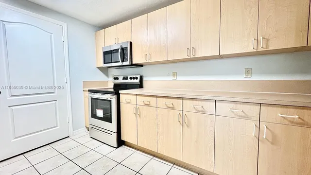 a kitchen with white cabinets and appliances