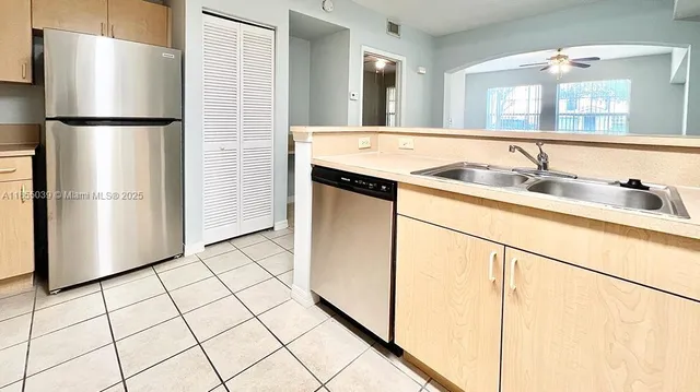 a kitchen with stainless steel appliances a refrigerator sink and cabinets