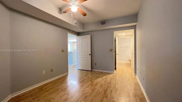 an empty room with wooden floor and door