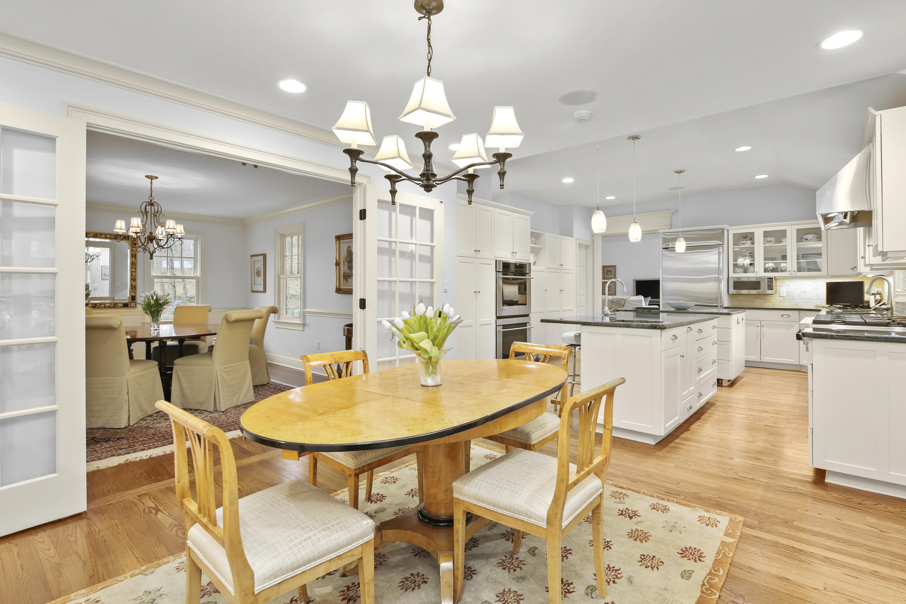 346 Frogtown Road New Canaan, CT 06840 - Photo 11 of 36 a dining room filled counter top space and a kitchen view with a chandelier