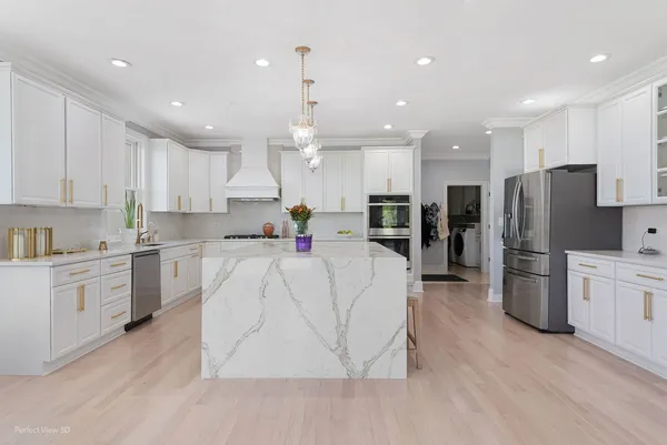 a large kitchen with stainless steel appliances refrigerator sink and cabinets
