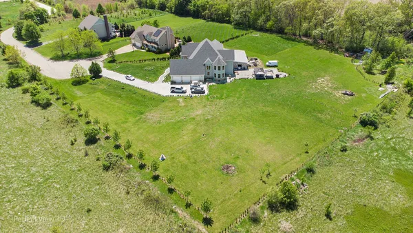 an aerial view of a house with swimming pool and green space