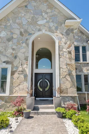 a stone building with potted plants in front of it
