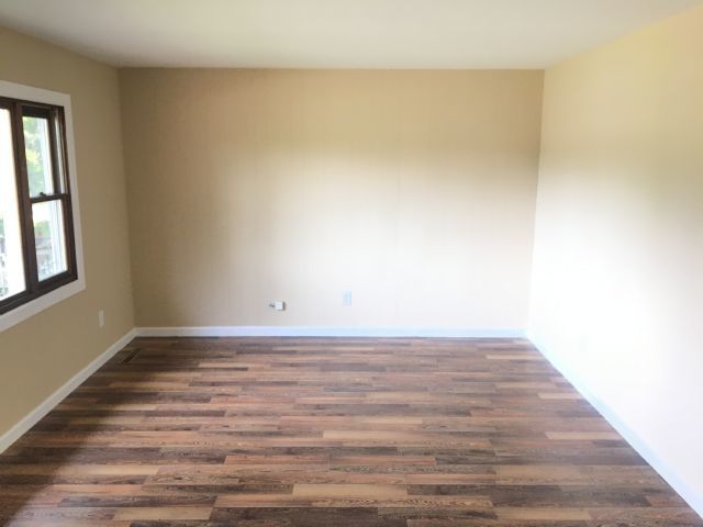 5707 Fox Lake Road McHenry, IL 60051 - Photo 4 of 14 a view of an empty room with wooden floor and a window