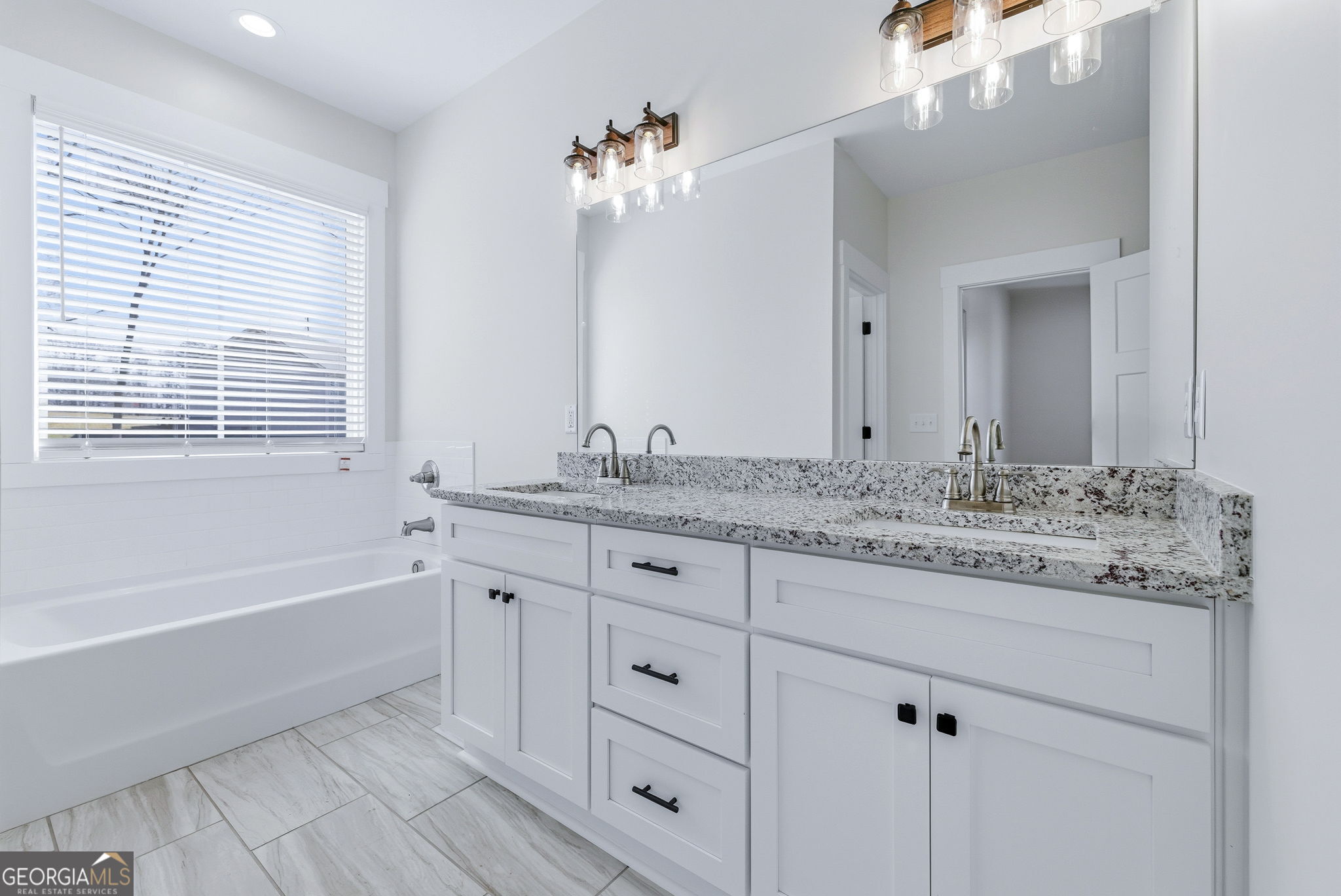 238 Carl Loudermilk Road Mount Airy, GA 30563 - Photo 15 of 28 a bathroom with a granite countertop double vanity sink a bathtub and mirror