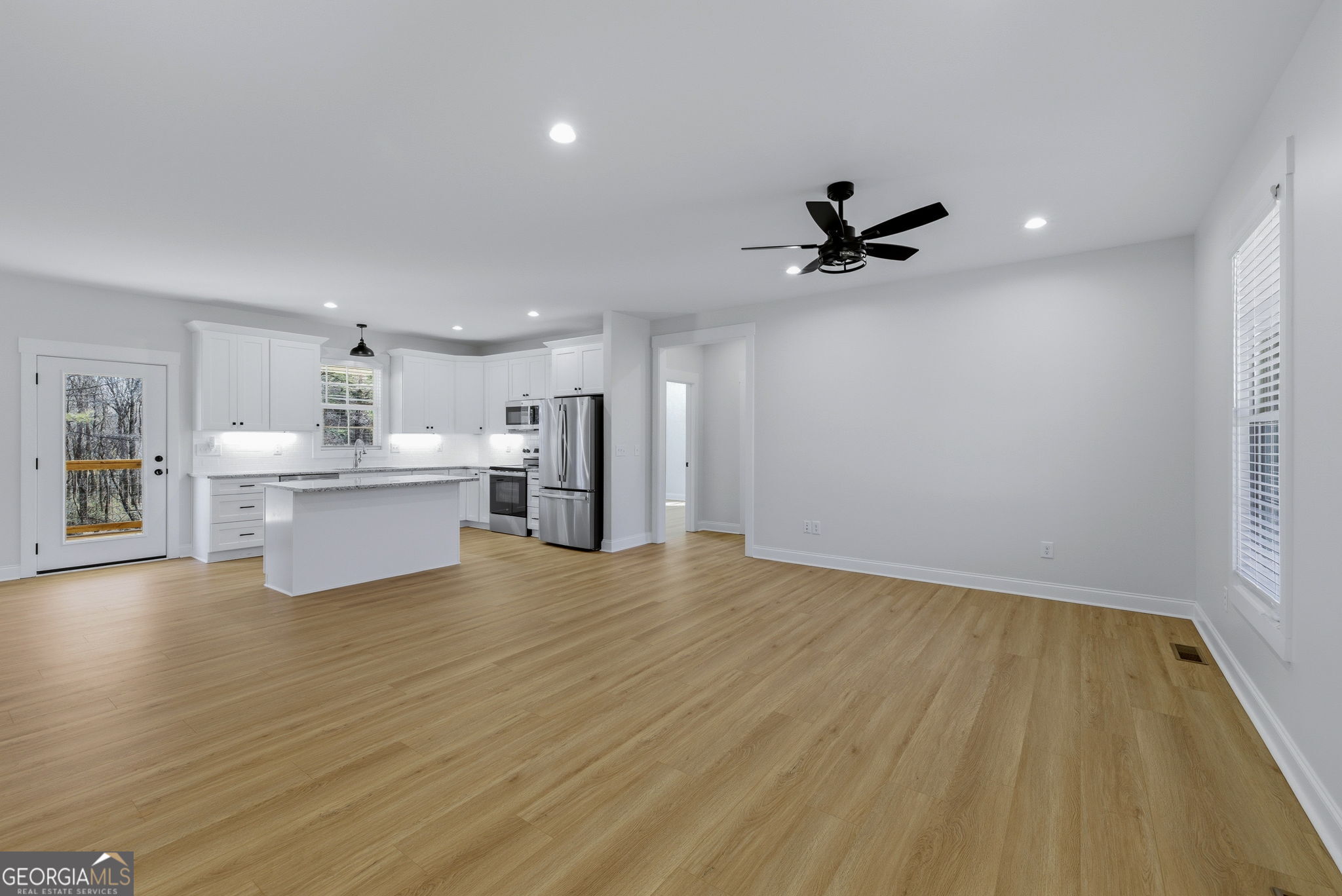 238 Carl Loudermilk Road Mount Airy, GA 30563 - Photo 4 of 28 a view of an empty room with a ceiling fan and wooden floor