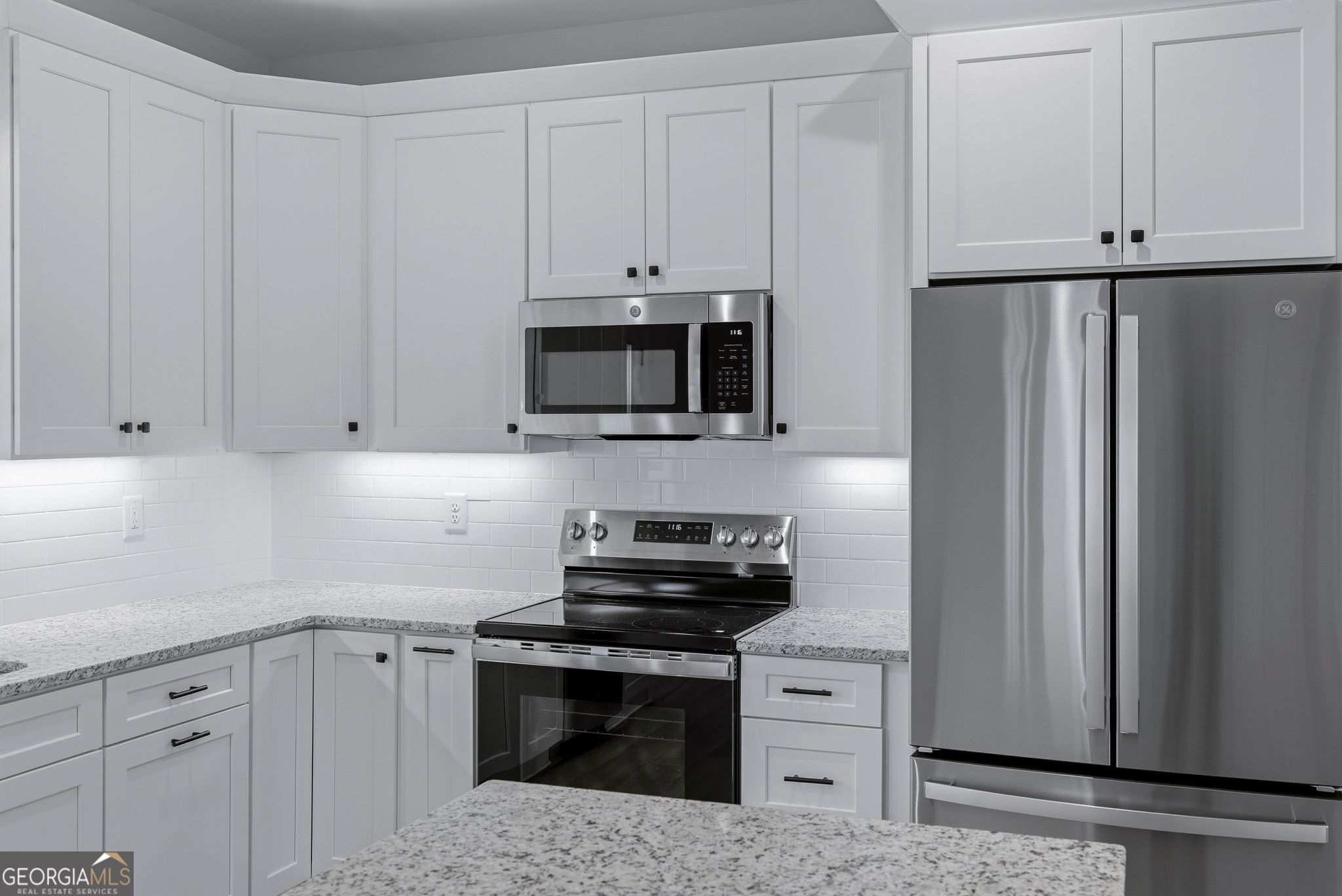 238 Carl Loudermilk Road Mount Airy, GA 30563 - Photo 8 of 28 a kitchen with white cabinets and stainless steel appliances