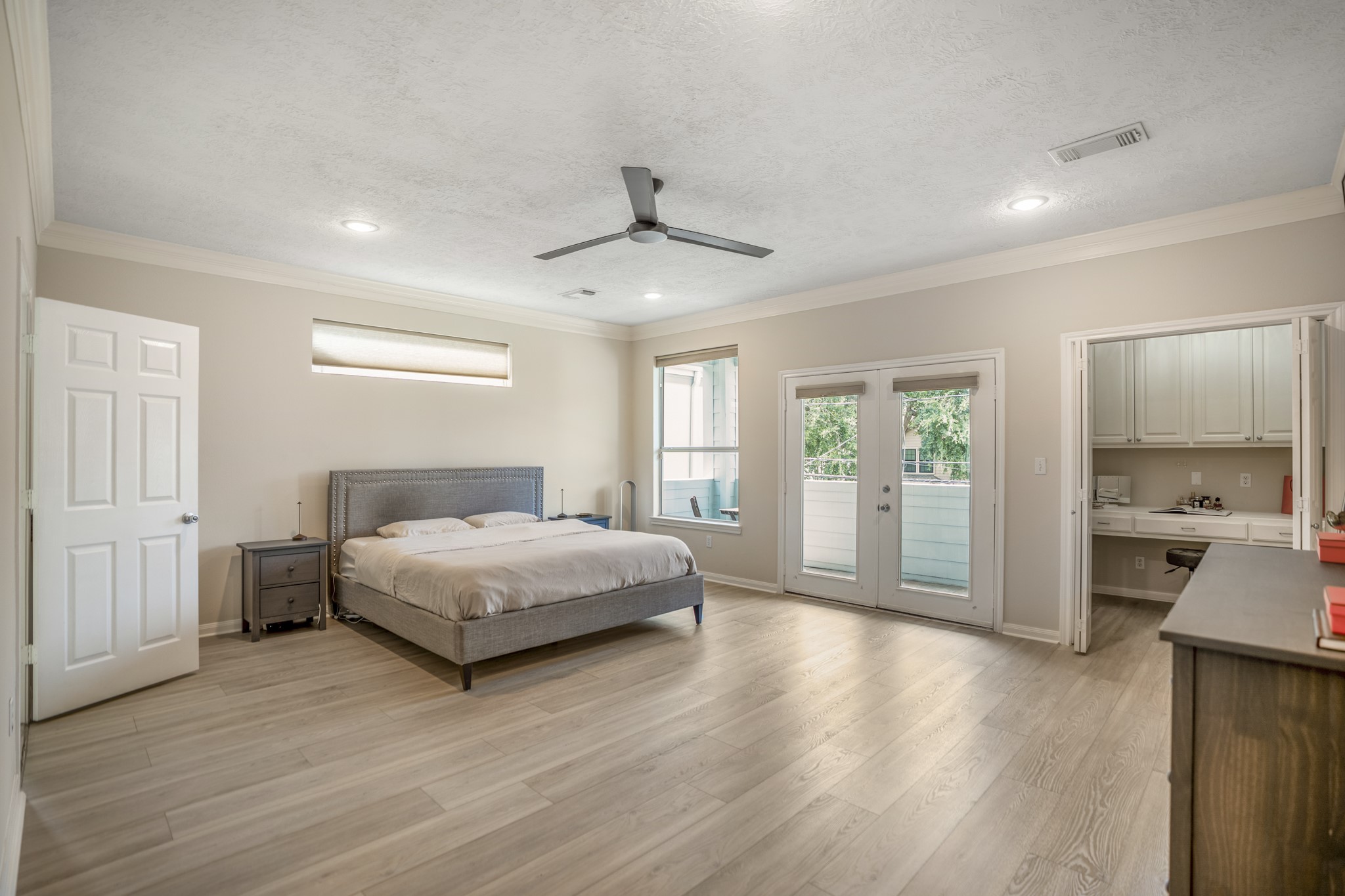 4236 Drake Street Houston, TX 77005 - Photo 16 of 43 The elegant second-floor primary suite with a private balcony offers a peaceful retreat with indoor-outdoor living, a separate study nook, which can also function as a designated vanity space.