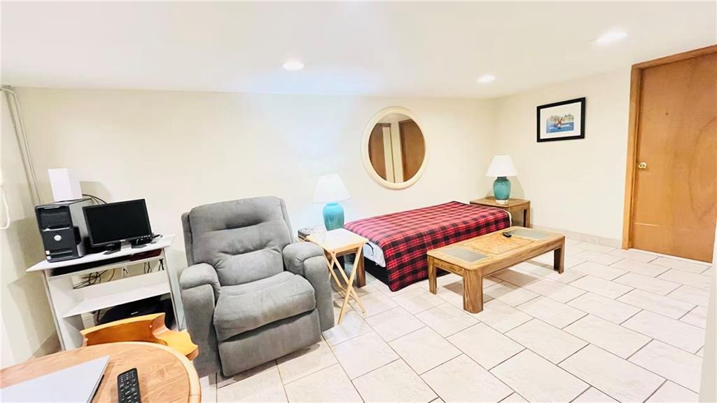 1673 83rd Street Brooklyn, NY 11214 - Photo 16 of 24 a living room with furniture a flat screen tv and a wall painting