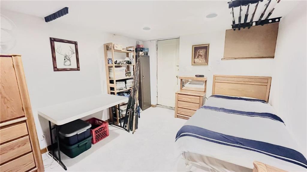 1673 83rd Street Brooklyn, NY 11214 - Photo 18 of 24 a bedroom with furniture and a book shelf