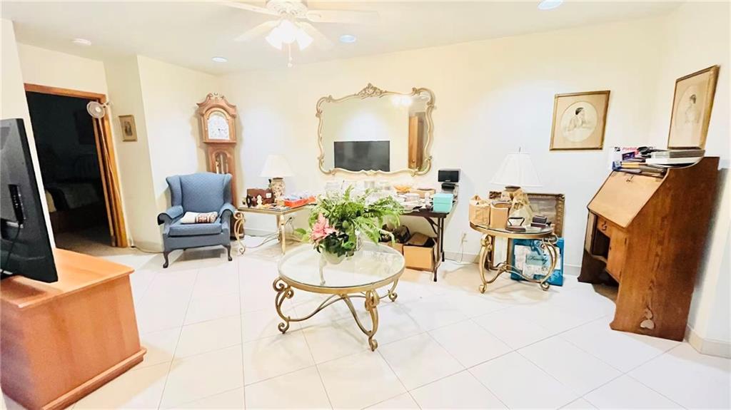 1673 83rd Street Brooklyn, NY 11214 - Photo 3 of 24 a living room with furniture a flat screen tv and a refrigerator