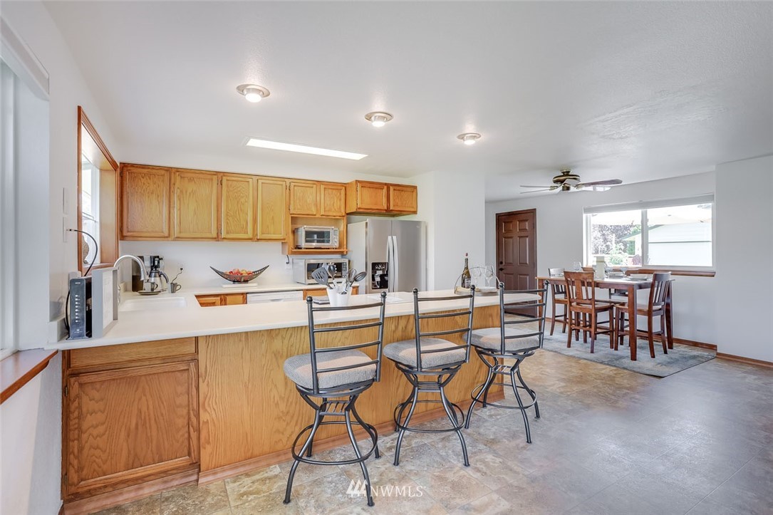 5209 Northeast 3rd Street Renton, WA 98059 - Photo 10 of 31 a kitchen with stainless steel appliances granite countertop table chairs sink and window