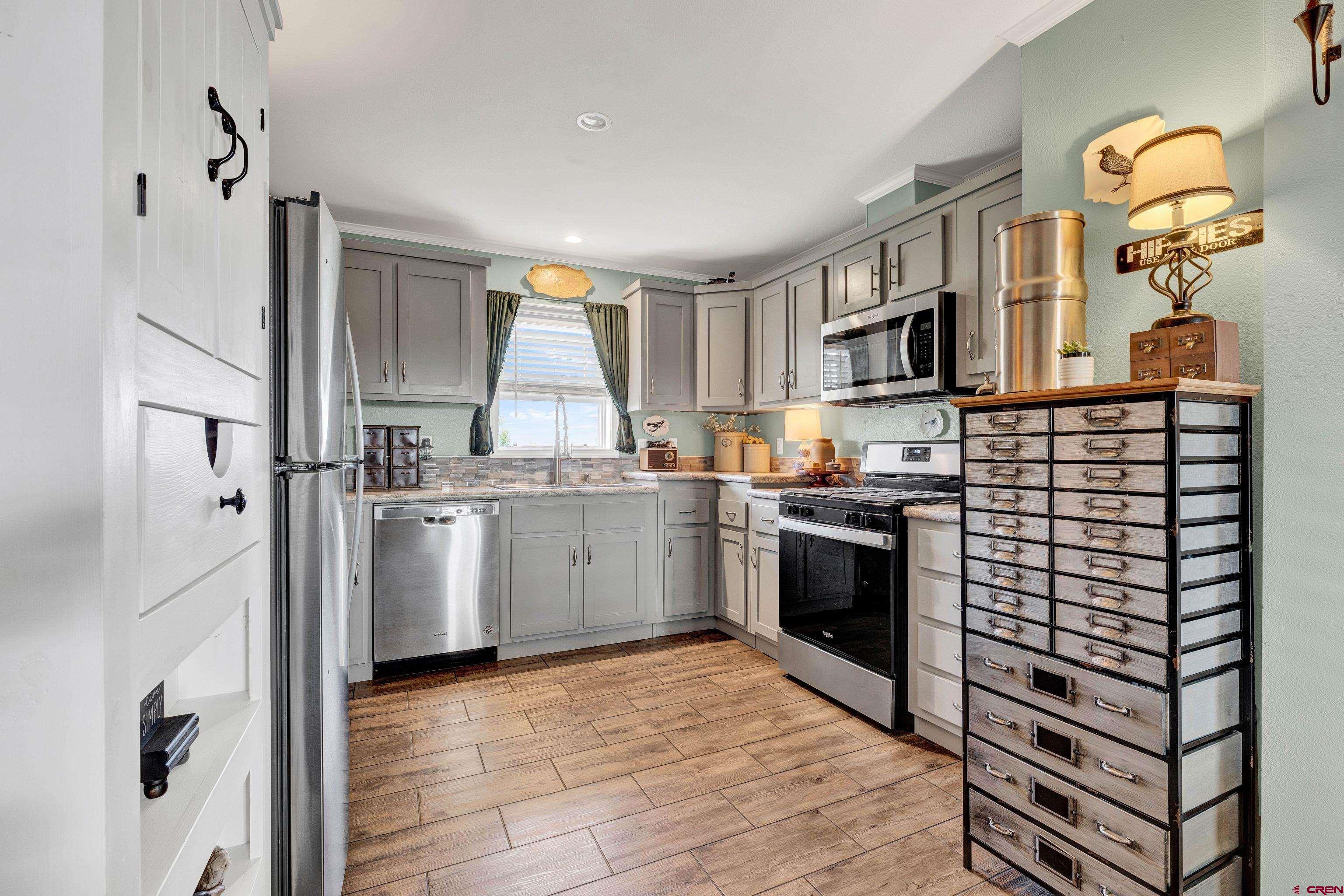 901 6530 Road, Unit 2813 Montrose, CO 81401 - Photo 11 of 34 a kitchen with cabinets and wooden floor