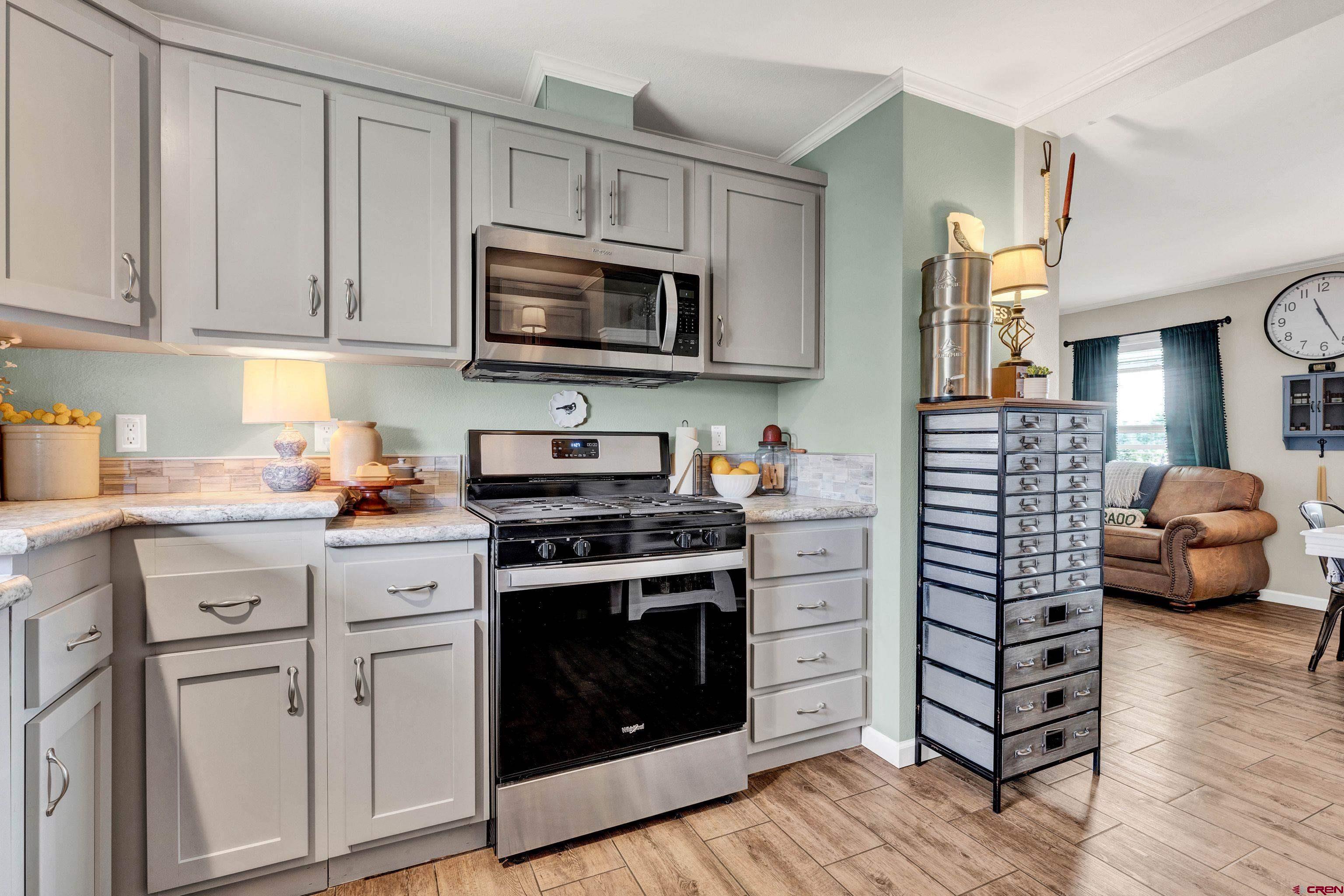 901 6530 Road, Unit 2813 Montrose, CO 81401 - Photo 13 of 34 a kitchen with white cabinets and stainless steel appliances