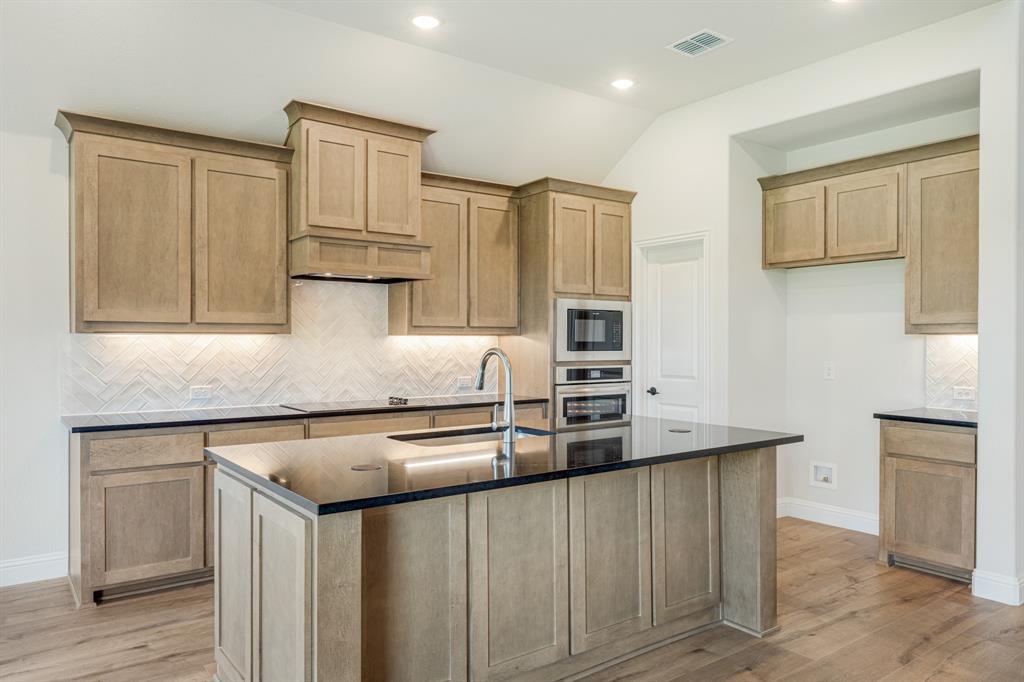 729 Seahawk Street Joshua, TX 76058 - Photo 15 of 40 a kitchen with stainless steel appliances granite countertop a sink and refrigerator