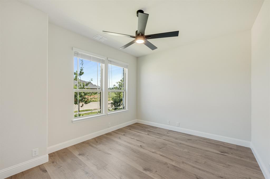 729 Seahawk Street Joshua, TX 76058 - Photo 6 of 40 an empty room with wooden floor fan and windows