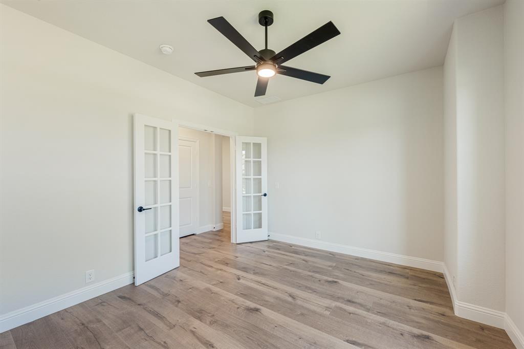 729 Seahawk Street Joshua, TX 76058 - Photo 7 of 40 an empty room with wooden floor and ceiling fan
