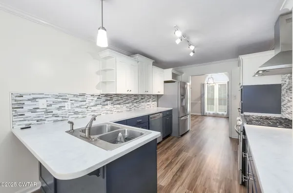 a kitchen with a sink a counter top space stainless steel appliances and cabinets