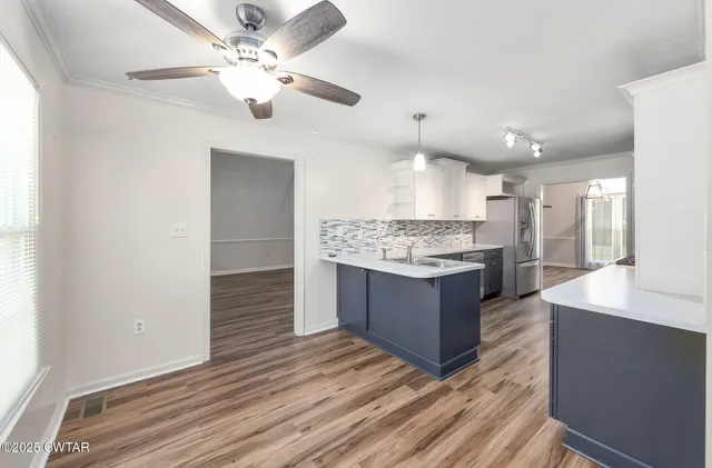a large kitchen with a center island and stainless steel appliances